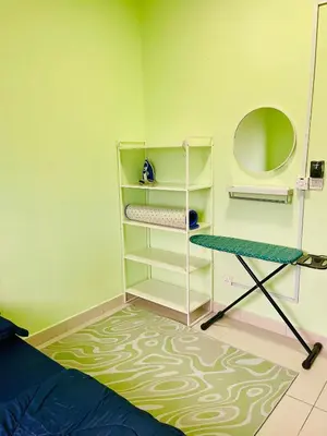 a bedroom with green walls and a bed and shelves at Homestay Kuala Lumpur in Kuala Lumpur