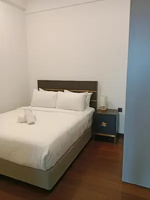 a bedroom with a large white bed and a night stand at OPUS LUXURY INFINiTY POOL KL in Kuala Lumpur