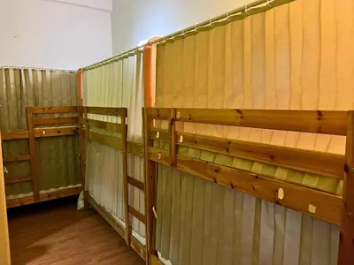 a row of wooden stalls in a room at PODs The Backpackers Home & Cafe, Kuala Lumpur in Kuala Lumpur