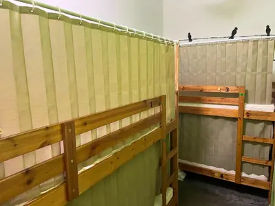 a row of wooden bunk beds in a room at PODs The Backpackers Home & Cafe, Kuala Lumpur in Kuala Lumpur