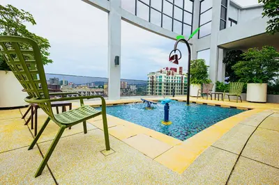 a green chair sitting on top of a building with a pool at The Atrium at Jalan Ampang by OKBnB - 3Bedroom Apartment with FREE WiFi & Carpark in Kuala Lumpur