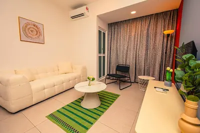 a living room with a white couch and a table at The Atrium at Jalan Ampang by OKBnB - Cozy 2 Bedroom, 3 mins to KLCC in Kuala Lumpur
