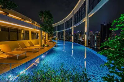 a hotel swimming pool with a view of the city at night at The Atrium at Jalan Ampang by OKBnB - Cozy 2 Bedroom, 3 mins to KLCC in Kuala Lumpur