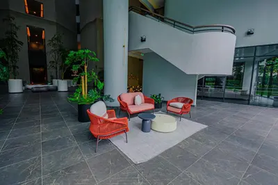 a lobby with red chairs and tables in a building at The Atrium at Jalan Ampang by OKBnB - Beautiful 2Bedroom nearby KLCC in Kuala Lumpur