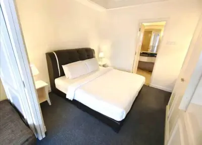 a bedroom with a white bed with a black headboard at KL Cozy Suite Apartment At Times Square in Kuala Lumpur