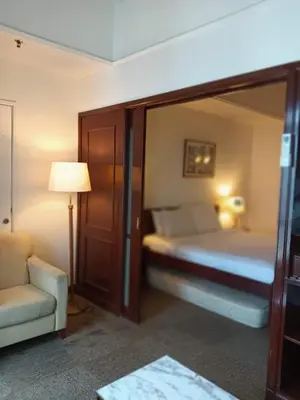 a hotel room with a bed and a couch and a lamp at KL Cozy Suite Apartment At Times Square in Kuala Lumpur