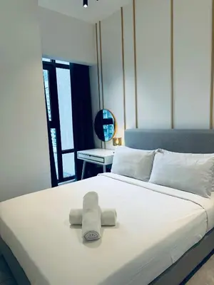a white bed with a towel on top of it at Axon Residence Bukit Bintang Pavilion KL in Kuala Lumpur