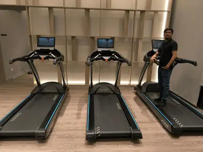 a man standing in front of three gym machines at Agile Service Suites Bukit Bintang By TRX in Kuala Lumpur