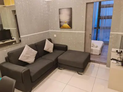 a living room with a black couch and a chair at THE ROBERSTSON RESIDENT WITH VIEW Kuala Lumpur in Kuala Lumpur