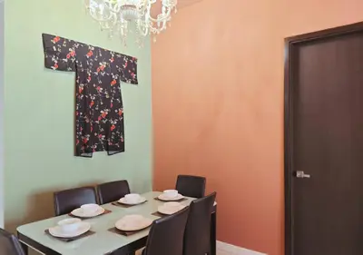 a room with a table with chairs and a letter t on the wall at The Element Condo 3BR with KL Skyscraper View in Kuala Lumpur