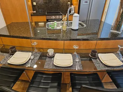 a kitchen with a table with chairs and wine glasses at Urban Oasis at St Mary klcc 1Bed2bath in Kuala Lumpur