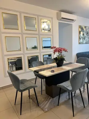 a dining room with a table and chairs and windows at The E48-10 Stay in Kuala Lumpur