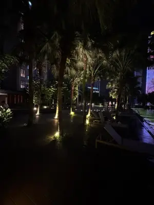 a courtyard with palm trees and lights at night at Agile Bukit Bintang by SOD in Kuala Lumpur