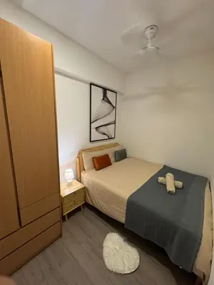 a small bedroom with a bed and a night stand at Agile Bukit Bintang by SOD in Kuala Lumpur