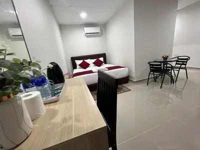 a room with a bed and a table and chairs at De Royal Hotel in Ampang