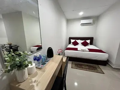 a hotel room with a bed and a mirror at De Royal Hotel in Ampang