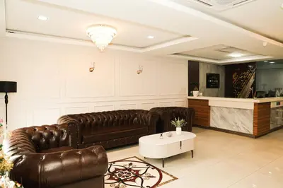 a living room with two leather couches and a table at De Royal Hotel in Ampang