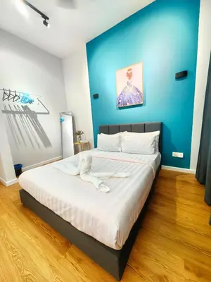 a large bed in a room with a blue wall at Chamber Residence By SKY Rainbow in Kuala Lumpur