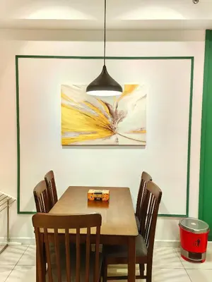 a dining room table with chairs and a painting on the wall at Chamber Residence By SKY Rainbow in Kuala Lumpur