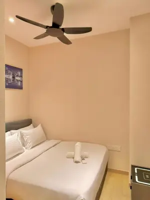 a bedroom with a white bed with a ceiling fan at PANORAMIC SUITES at Eaton residence in Kuala Lumpur