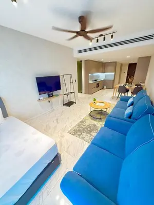 a living room with a blue couch and a tv at PANORAMIC SUITES at Eaton residence in Kuala Lumpur