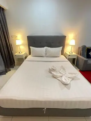 a large white bed with two white towels on it at SP Home At Mercu Summer Suites in Kuala Lumpur