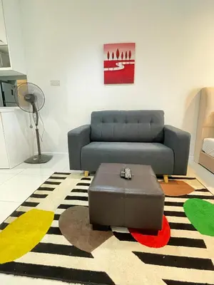 a living room with a couch and a table at SP Home At Mercu Summer Suites in Kuala Lumpur
