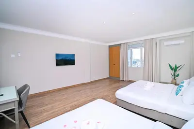 a hotel room with two beds and a desk at Kingston Hotel 11 - PWTC, KL in Kuala Lumpur
