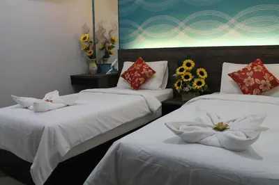 three beds in a room with flowers on them at Signature Hotel @ Bangsar South in Kuala Lumpur