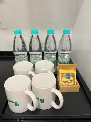 a tray with four bottles of water and two cups at Societe by Bamboo Hospitality in Kuala Lumpur