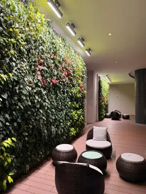 a large green wall with stools and chairs in a lobby at Eaton Residence KLCC in Kuala Lumpur