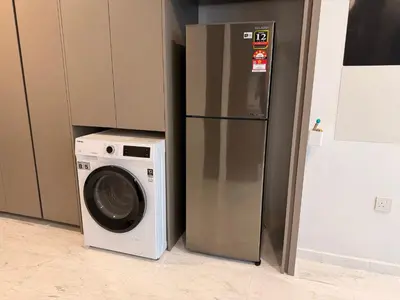 a refrigerator next to a washing machine in a room at Eaton Residence KLCC in Kuala Lumpur