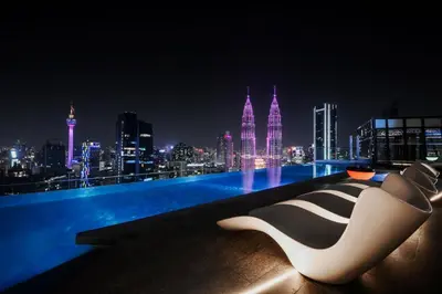 a white and black chair sitting on a rooftop at night at Imperial KLCC by Premium Hospitality in Kuala Lumpur