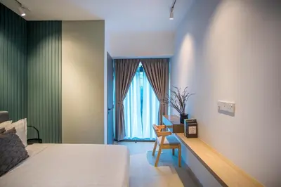 a bedroom with a bed and a chair and a window at Eaton Kuala Lumpur with KLCC Skyline View Pool in Kuala Lumpur