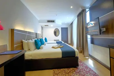 a hotel room with a large bed and a desk at Howard Johnson By Wyndham Kuala Lumpur 118 in Kuala Lumpur