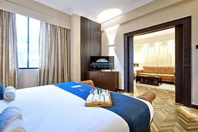 a hotel room with a bed with shoes on it at Howard Johnson By Wyndham Kuala Lumpur 118 in Kuala Lumpur