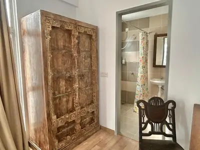 a room with a large wooden door and a chair at 3BR Vintage design Level 26, KL Sentral City View in Kuala Lumpur