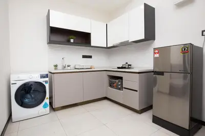 a kitchen with a refrigerator and a washer and dryer at Luxe Suite in Kuala Lumpur