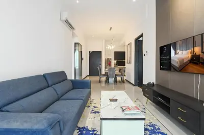 a living room with a blue couch and a tv at Luxe Suite in Kuala Lumpur