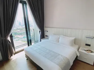 a bedroom with a white bed and a large window at Luxe Suite in Kuala Lumpur