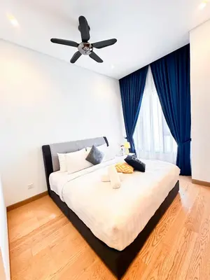 a bedroom with a large bed with a ceiling fan at Lucentia Global Luxe Suites Kuala Lumpur in Kuala Lumpur
