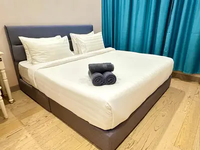a bed with a black object on top of it at Lucentia Global Luxe Suites Kuala Lumpur in Kuala Lumpur