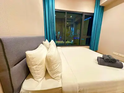 a hotel room with a bed with a view of a city at Lucentia Global Luxe Suites Kuala Lumpur in Kuala Lumpur