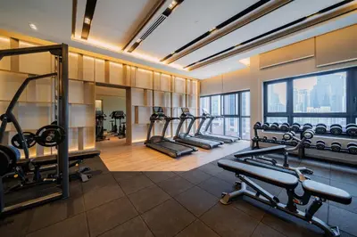 a gym with a row of treadmills and machines at Agile Bukit Bintang TRX Pavilion KL by WSD in Kuala Lumpur