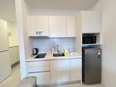 a small kitchen with a sink and a refrigerator at Serenity Stay in Chambers Residence in Kuala Lumpur