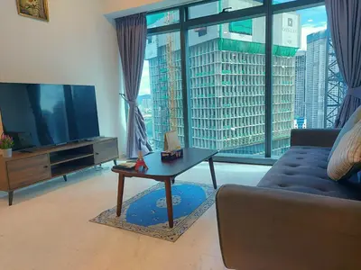 a living room with a couch and a table and a large window at Eaton Residence KLCC Elite Suites in Kuala Lumpur