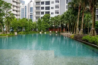 a pool of blue water with palm trees and buildings at KidsCastle Bukit Bintang Slide Family Friendly in Kuala Lumpur