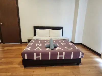 a bedroom with a bed with a purple and white blanket at Regalia Suites Best Couples Studio KLCC in Kuala Lumpur