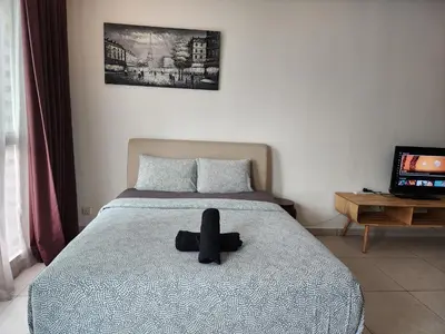 a black hat sitting on a bed in a bedroom at Regalia Suites Best Couples Studio KLCC in Kuala Lumpur
