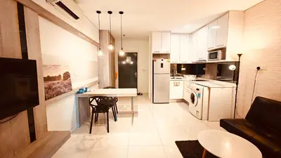 a kitchen and living room with a table and chairs at Mercu Summer Suites KL City Centre in Kuala Lumpur